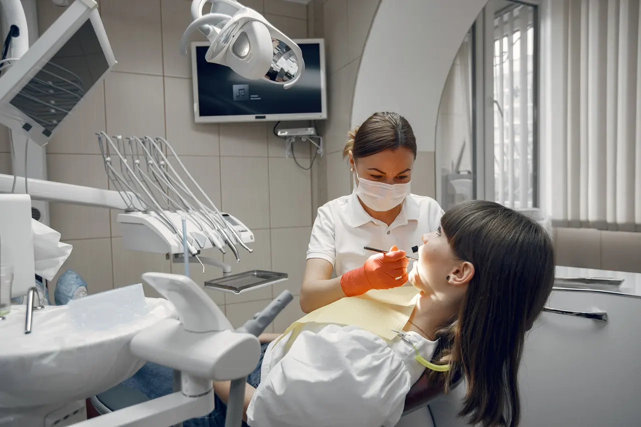 A dentist caring for a young patient in the chair