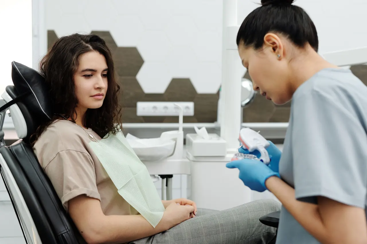 A dental clinician in gloves and a mask attending to a patient during a check-up